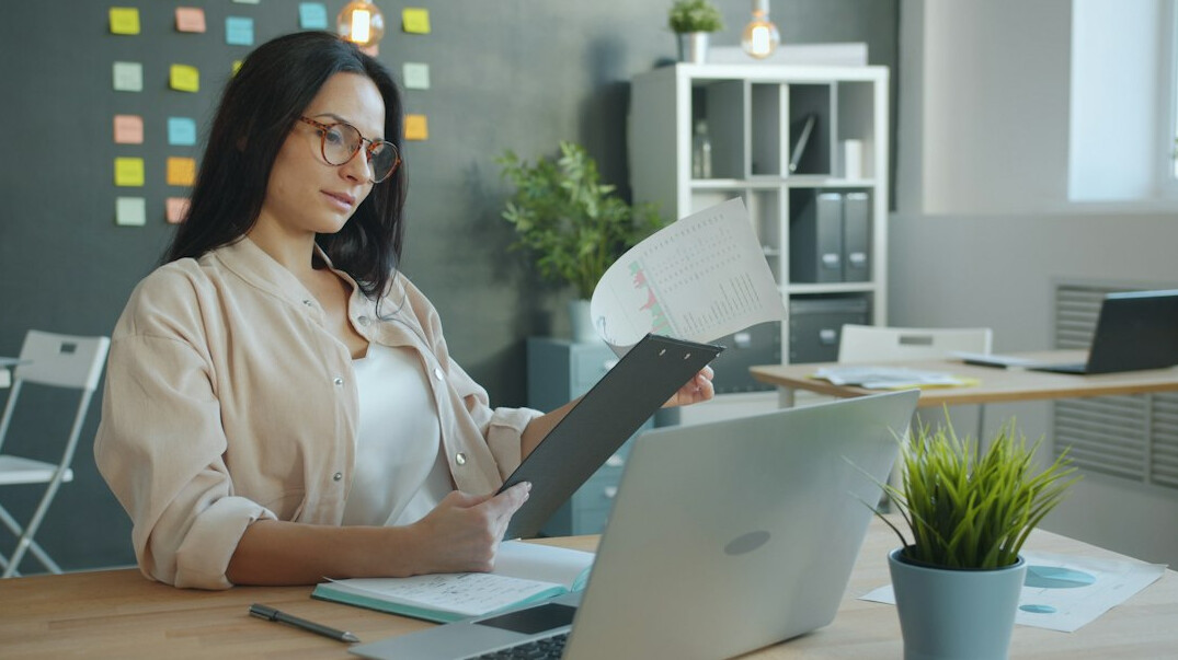 woman checking documents at desk